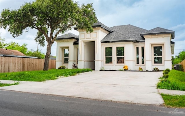 607 N 9th St, Alamo, TX 78516 - view of front facade with roof with shingles, stucco siding, and driveway