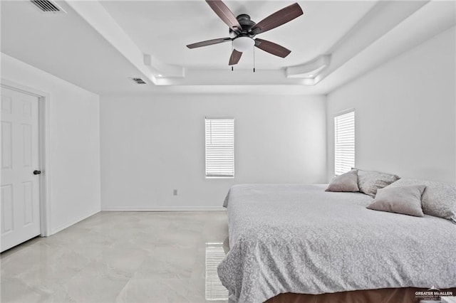 bedroom with a tray ceiling and ceiling fan