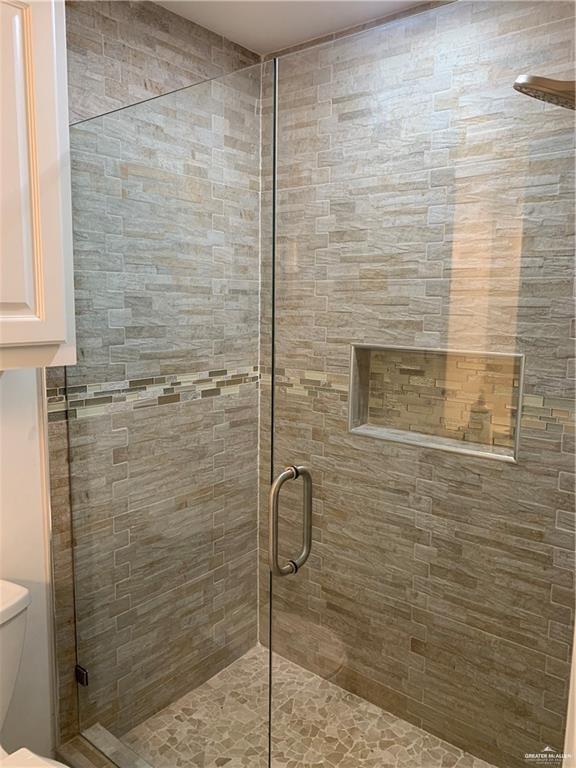 bathroom featuring an enclosed shower and toilet