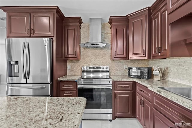 kitchen featuring decorative backsplash, stainless steel appliances, light stone counters, and wall chimney exhaust hood