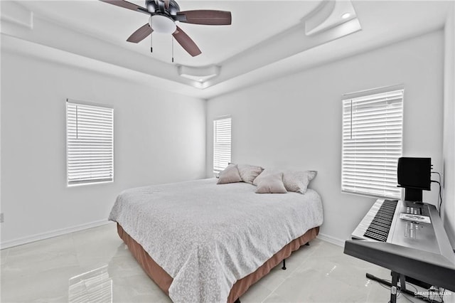 bedroom featuring a raised ceiling and ceiling fan