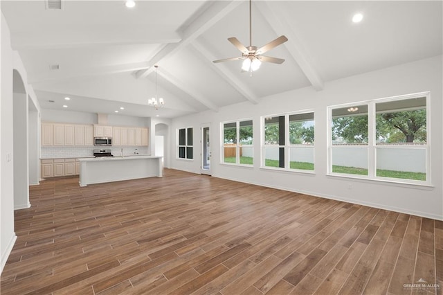 unfurnished living room featuring vaulted ceiling with beams, dark hardwood / wood-style floors, and ceiling fan with notable chandelier