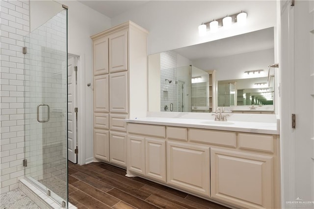 bathroom featuring hardwood / wood-style flooring, vanity, and a shower with shower door