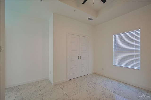 unfurnished bedroom featuring marble finish floor, a closet, visible vents, ceiling fan, and baseboards