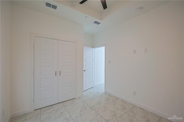 unfurnished bedroom featuring marble finish floor, a closet, visible vents, and baseboards