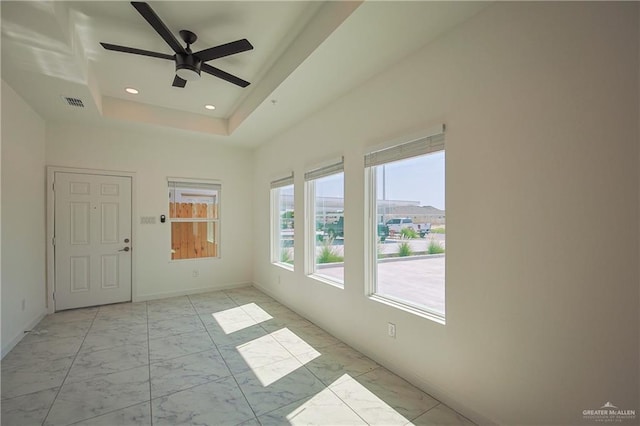 spare room with marble finish floor, recessed lighting, a raised ceiling, visible vents, and baseboards