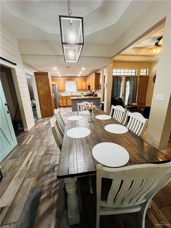 2031 Pena St, Mission, TX 78572 - dining room featuring a raised ceiling, wood finished floors, recessed lighting, and a barn door