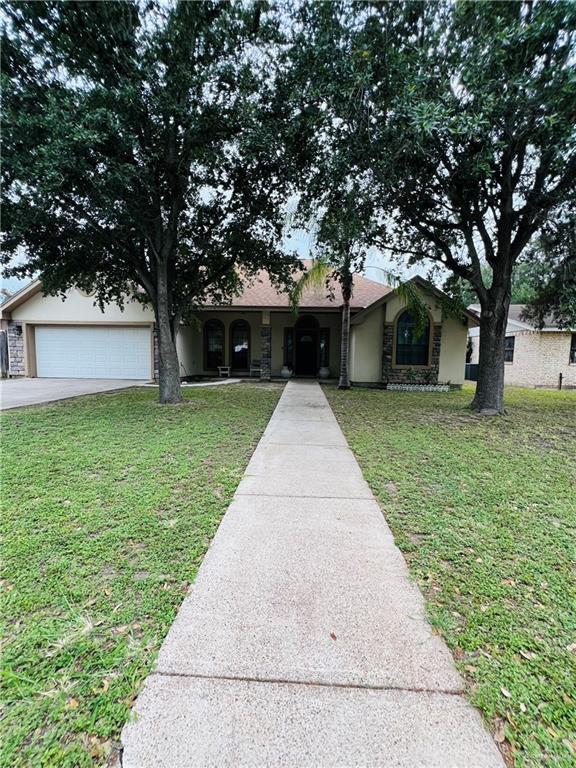 2031 Pena St, Mission, TX 78572 - ranch-style home featuring a front yard, driveway, an attached garage, and stucco siding
