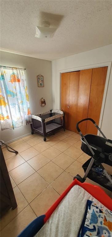 1319 Sago Palm St, Alamo, TX 78516 - bedroom with a textured ceiling, light tile patterned floors, and a closet