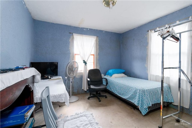 bedroom featuring concrete flooring