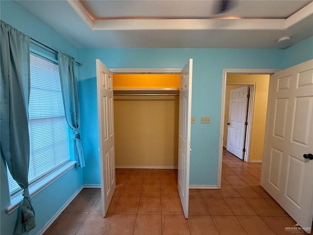 1008 Ivory Ave, Rio Grande City, TX 78582 - unfurnished bedroom featuring a raised ceiling, baseboards, light tile patterned flooring, and a closet