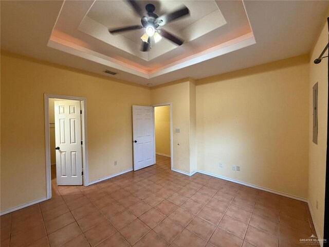 1008 Ivory Ave, Rio Grande City, TX 78582 - unfurnished bedroom featuring a tray ceiling, baseboards, and a ceiling fan
