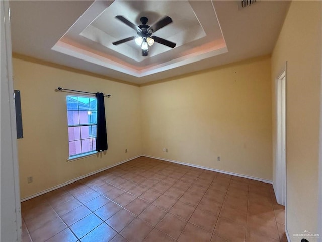 1008 Ivory Ave, Rio Grande City, TX 78582 - empty room featuring ceiling fan, a tray ceiling, tile patterned flooring, and baseboards