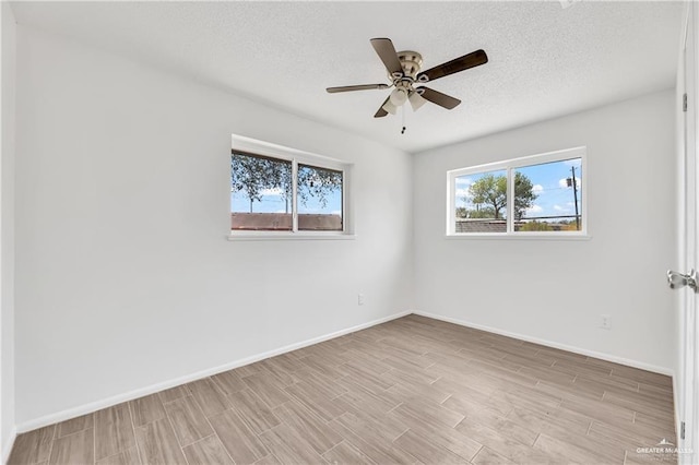 empty room featuring a textured ceiling, light hardwood / wood-style flooring, and ceiling fan