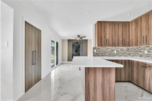 kitchen featuring tasteful backsplash, kitchen peninsula, and ceiling fan