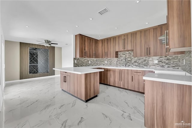 kitchen with black electric stovetop, sink, ceiling fan, tasteful backsplash, and a kitchen island