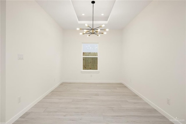5204 Shalom Dr, Edinburg, TX 78539 - spare room with a chandelier, light wood-style flooring, a raised ceiling, recessed lighting, and baseboards