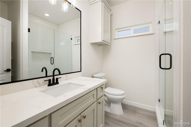 5204 Shalom Dr, Edinburg, TX 78539 - full bath with toilet, wood finished floors, vanity, a stall shower, and baseboards