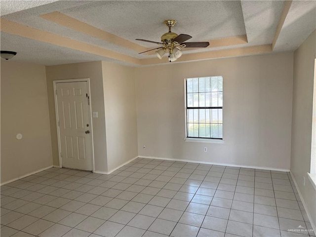 412 Silverado Dr E, Palmview, TX 78572 - spare room featuring a textured ceiling, a tray ceiling, light tile patterned floors, a ceiling fan, and baseboards