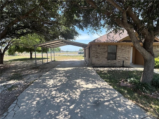 412 Silverado Dr E, Palmview, TX 78572 - view of side of property featuring concrete driveway, a carport, and brick siding