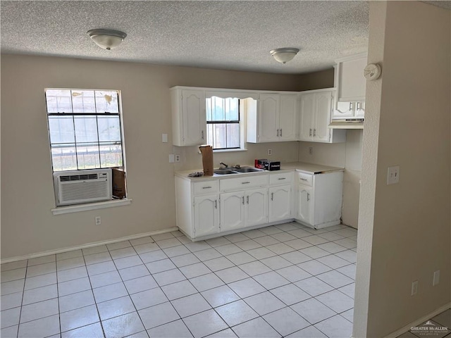412 Silverado Dr E, Palmview, TX 78572 - kitchen featuring a textured ceiling, cooling unit, white cabinetry, and light tile patterned floors