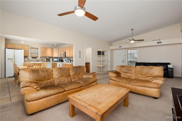 living room with ceiling fan, light colored carpet, and vaulted ceiling