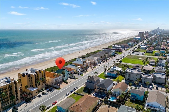 birds eye view of property with a water view and a beach view