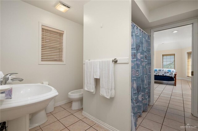 bathroom featuring toilet, tile patterned flooring, and sink