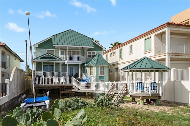 rear view of house with a gazebo and a wooden deck