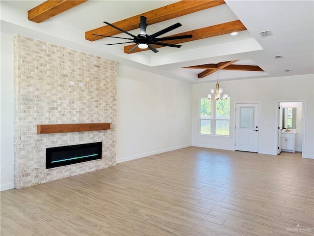 2125 Blue Sky Dr, Weslaco, TX 78599 - unfurnished living room featuring beam ceiling, a chandelier, light wood finished floors, a brick fireplace, and a ceiling fan