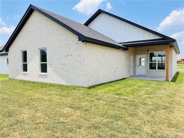 2125 Blue Sky Dr, Weslaco, TX 78599 - rear view of house featuring board and batten siding, a patio area, brick siding, and a yard