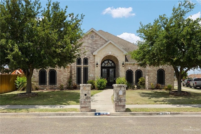 view of front of property featuring french doors and a front lawn