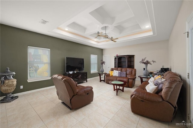 living room with ceiling fan, light tile patterned floors, and a tray ceiling