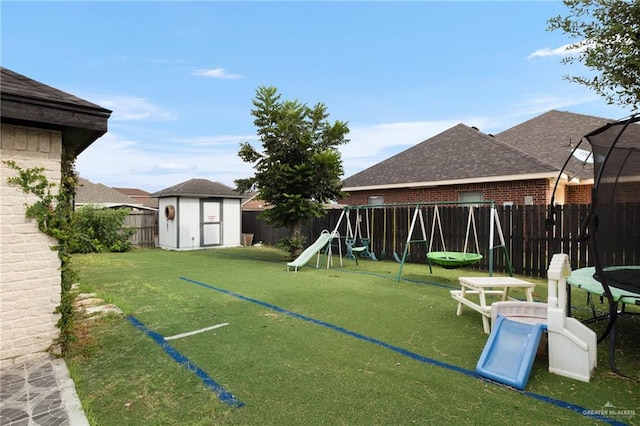 view of yard with a playground, a trampoline, and a shed