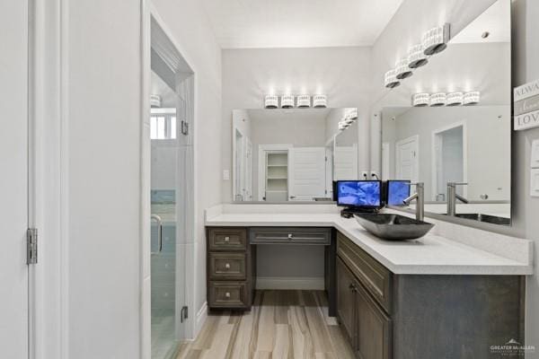 bathroom featuring hardwood / wood-style flooring, vanity, and a shower with shower door