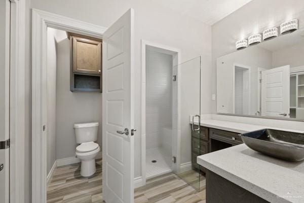 bathroom featuring hardwood / wood-style flooring, vanity, toilet, and an enclosed shower