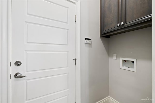 clothes washing area featuring washer hookup and cabinets