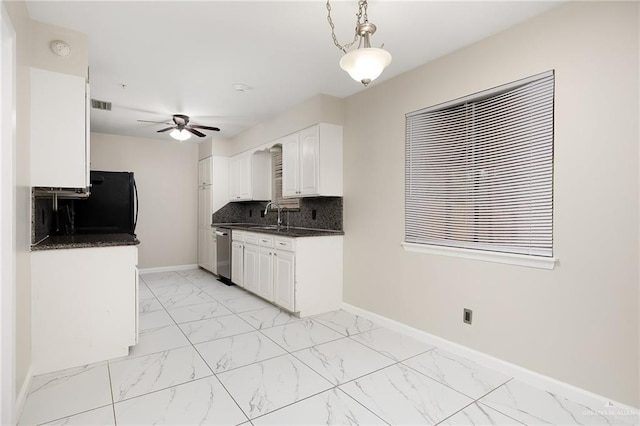 kitchen with dark countertops, marble finish floor, baseboards, and dishwasher