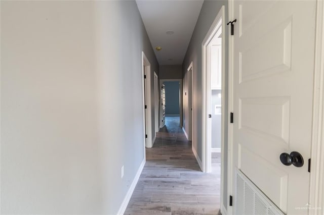 hallway with hardwood / wood-style flooring