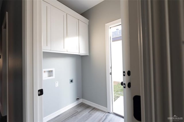 clothes washing area featuring cabinets, washer hookup, hookup for an electric dryer, and light hardwood / wood-style floors