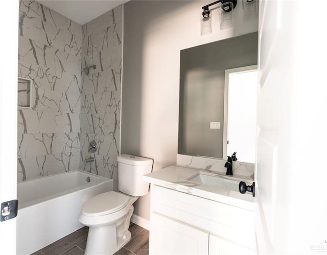 full bathroom featuring tiled shower / bath combo, vanity, and toilet