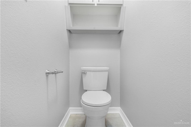 bathroom with tile patterned floors, toilet, and baseboards