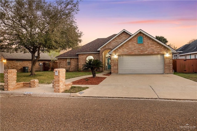 ranch-style house featuring brick siding, an attached garage, a front yard, fence, and driveway