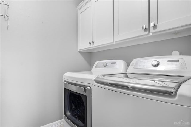 laundry area with separate washer and dryer, cabinet space, and baseboards