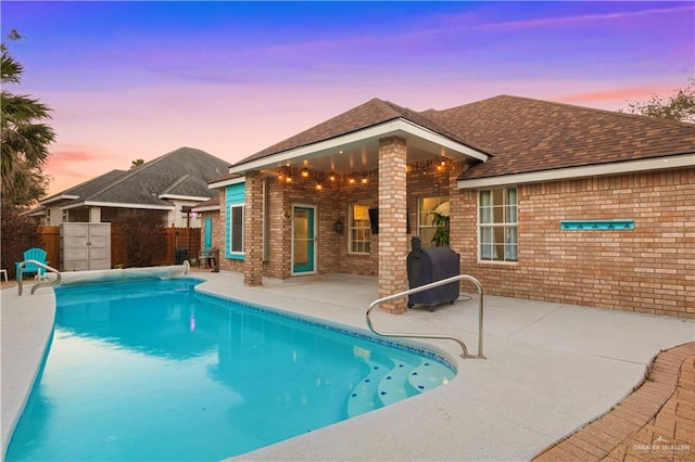 view of swimming pool with a patio area, fence, and a fenced in pool