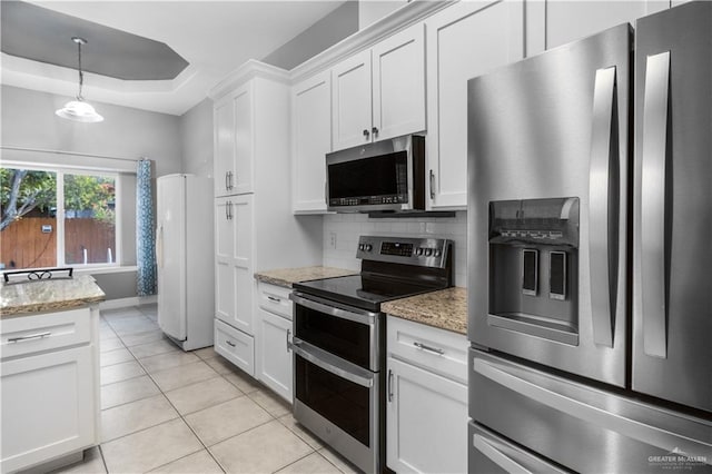 kitchen with light tile patterned floors, stainless steel appliances, white cabinetry, tasteful backsplash, and a raised ceiling