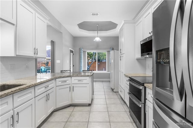 kitchen with stainless steel appliances, visible vents, decorative backsplash, and white cabinetry