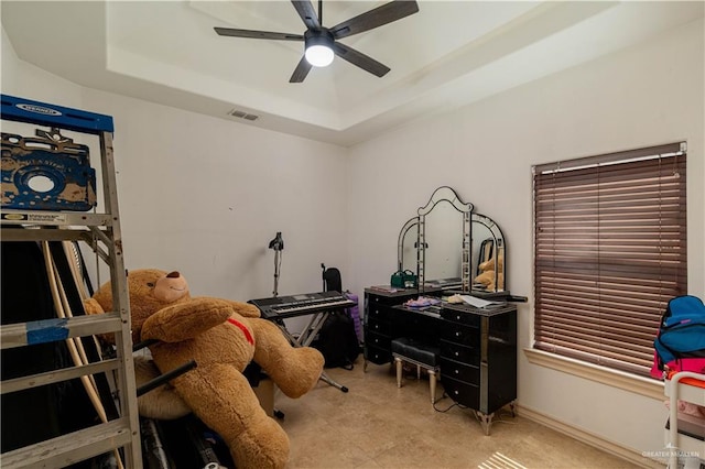 home office featuring a raised ceiling and ceiling fan