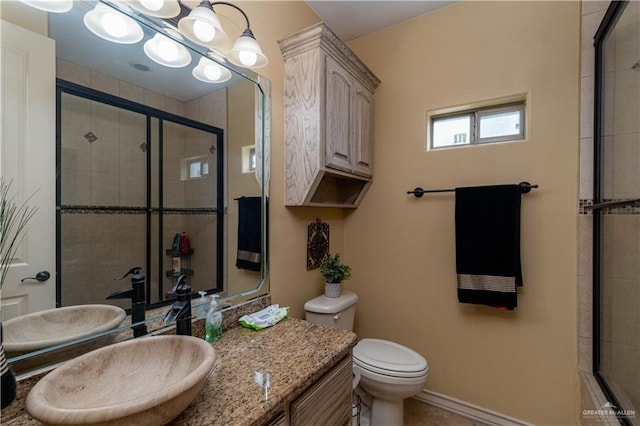 bathroom featuring vanity, a shower with shower door, and toilet