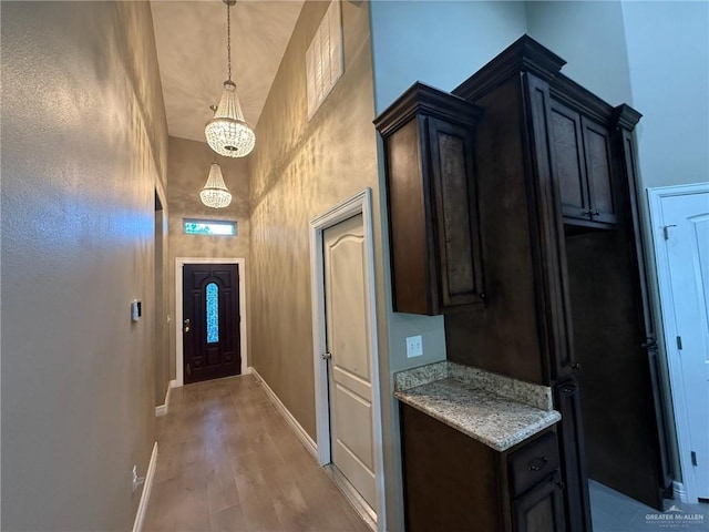 2315 N Ruby Dr, Edinburg, TX 78541 - doorway featuring a chandelier, a high ceiling, baseboards, and light wood finished floors